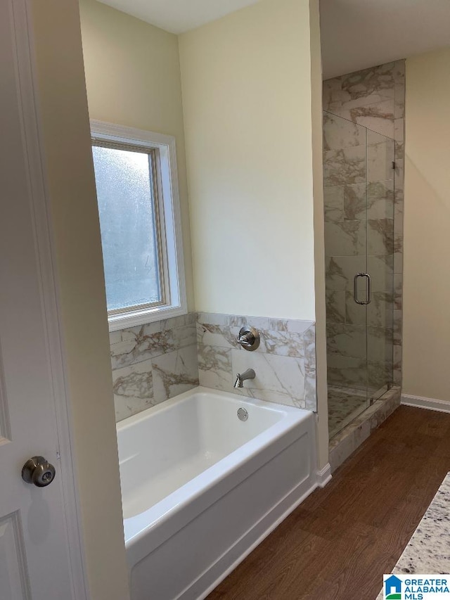 bathroom featuring wood-type flooring and independent shower and bath