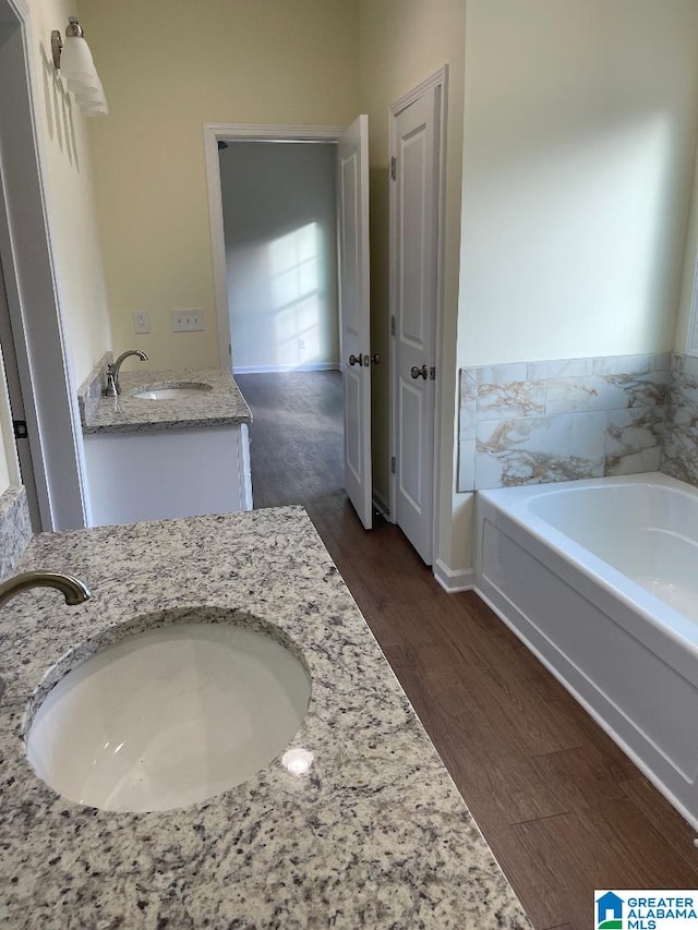 bathroom featuring hardwood / wood-style flooring, vanity, and a bathtub