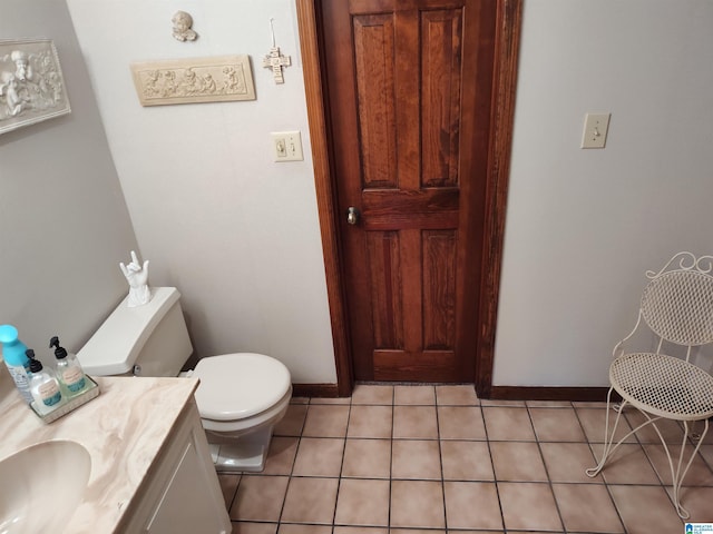 half bathroom with tile patterned floors, vanity, toilet, and baseboards
