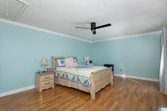 bedroom featuring ornamental molding, wood finished floors, attic access, and baseboards