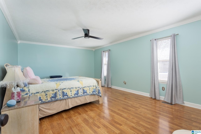 bedroom with ornamental molding, baseboards, light wood finished floors, and a ceiling fan