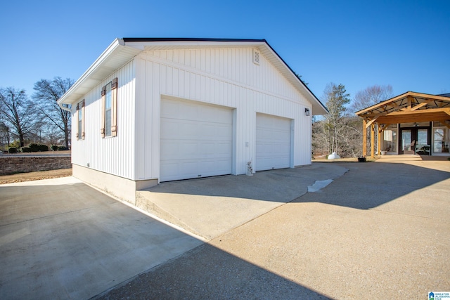 exterior space featuring a garage, an outbuilding, and french doors