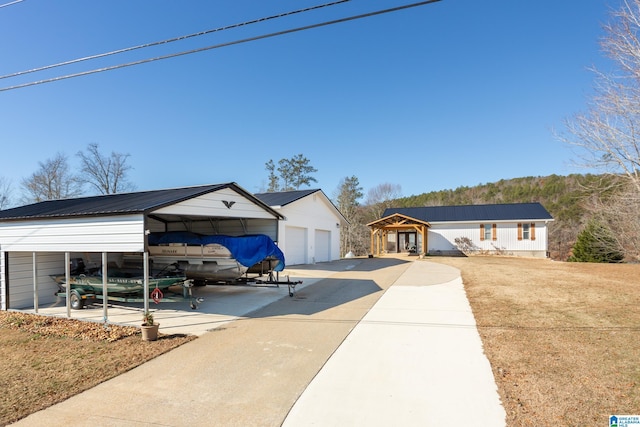 ranch-style house with a carport, a garage, and an outbuilding