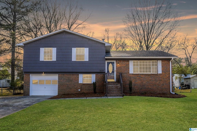 tri-level home featuring brick siding, driveway, an attached garage, and a lawn