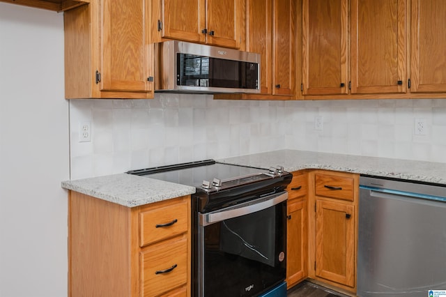 kitchen with tasteful backsplash, light stone countertops, and stainless steel appliances