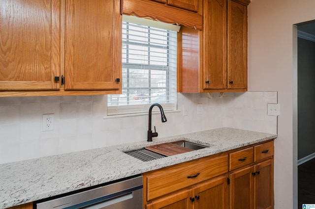 kitchen with dishwasher, sink, light stone counters, plenty of natural light, and decorative backsplash