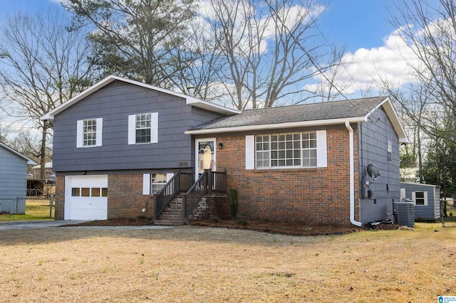 split level home featuring a front yard, central AC unit, and a garage