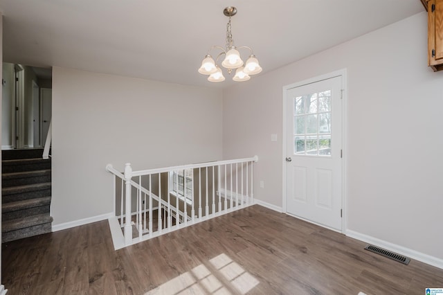 unfurnished dining area featuring hardwood / wood-style floors and an inviting chandelier