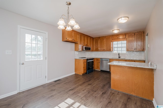 kitchen featuring hanging light fixtures, sink, dark hardwood / wood-style floors, decorative backsplash, and appliances with stainless steel finishes