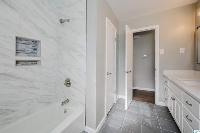 bathroom featuring tile patterned floors, tiled shower / bath combo, and vanity