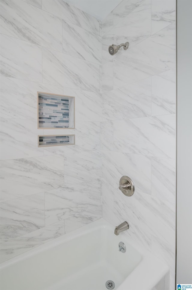 bathroom featuring tiled shower / bath