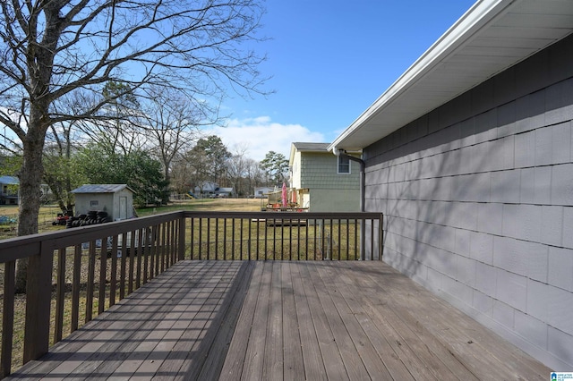 wooden terrace featuring a shed and a lawn