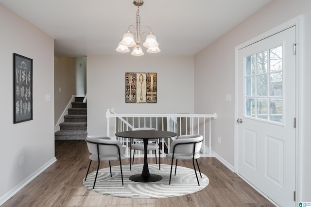 dining space featuring hardwood / wood-style floors and a notable chandelier