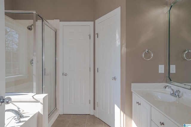 bathroom featuring tile patterned flooring, vanity, and a shower with shower door