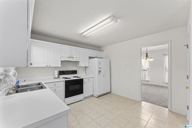 kitchen with white appliances, sink, pendant lighting, a notable chandelier, and white cabinets