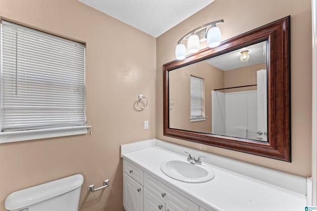 bathroom featuring vanity, a shower, toilet, and a textured ceiling