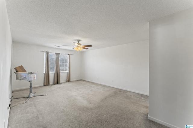 unfurnished room featuring light carpet, ceiling fan, and a textured ceiling