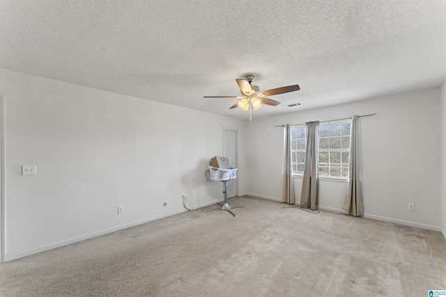 carpeted empty room with ceiling fan and a textured ceiling