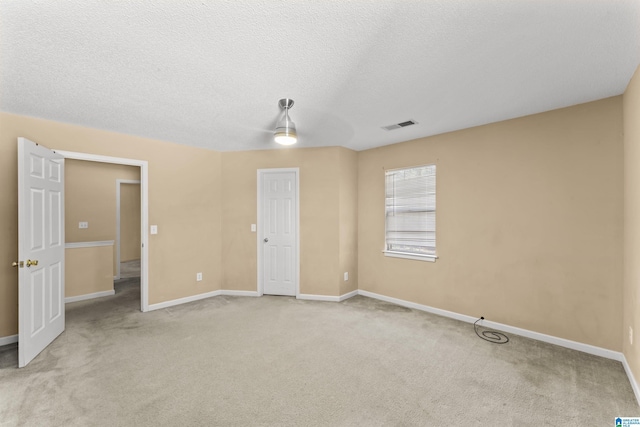 carpeted spare room with a textured ceiling