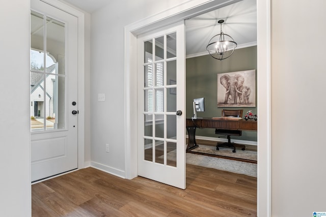 doorway with hardwood / wood-style floors, a notable chandelier, a wealth of natural light, and french doors