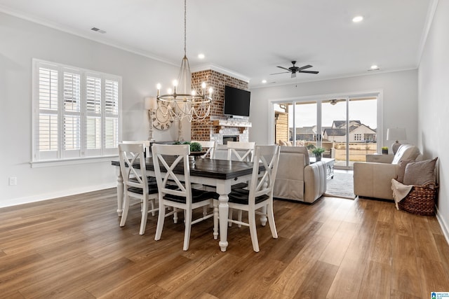 dining room featuring ceiling fan with notable chandelier, hardwood / wood-style flooring, and ornamental molding