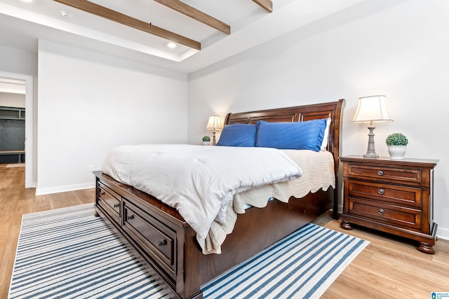 bedroom with beam ceiling and light wood-type flooring