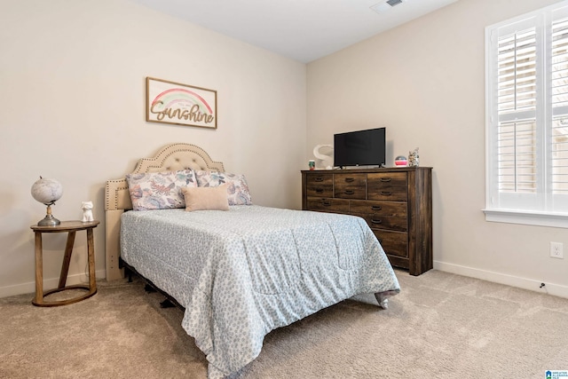 bedroom with light colored carpet and multiple windows