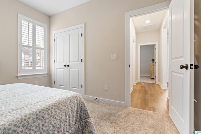 bedroom with light carpet and a closet