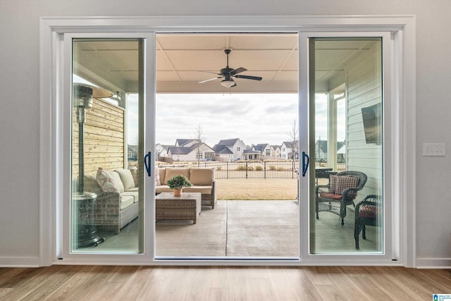 doorway with ceiling fan, a healthy amount of sunlight, and light hardwood / wood-style floors