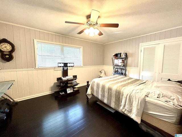 bedroom with ceiling fan, a closet, crown molding, and dark hardwood / wood-style floors