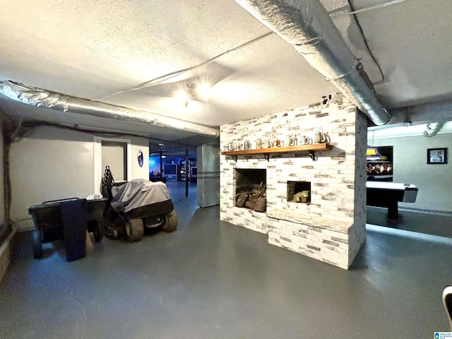 basement featuring stainless steel refrigerator, a textured ceiling, and pool table