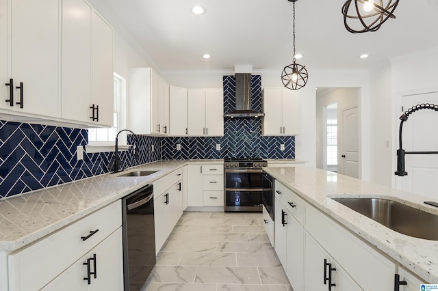 kitchen featuring light stone counters, wall chimney exhaust hood, pendant lighting, dishwasher, and white cabinetry