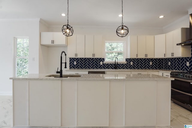 kitchen featuring pendant lighting, black range, a kitchen island with sink, and sink