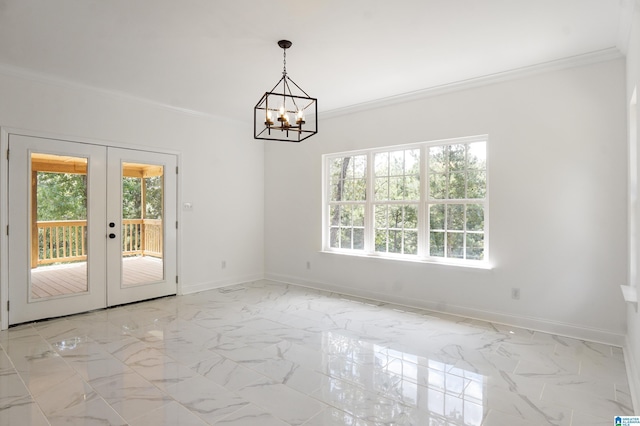 spare room featuring a notable chandelier, ornamental molding, and french doors