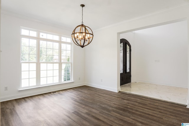 spare room with dark hardwood / wood-style floors, french doors, crown molding, and an inviting chandelier