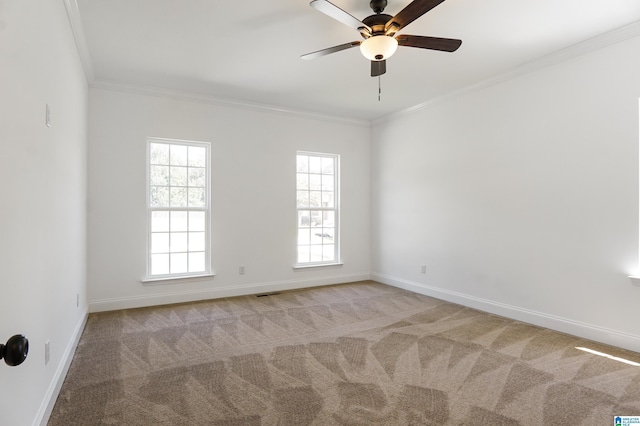 empty room featuring light colored carpet, ceiling fan, and crown molding