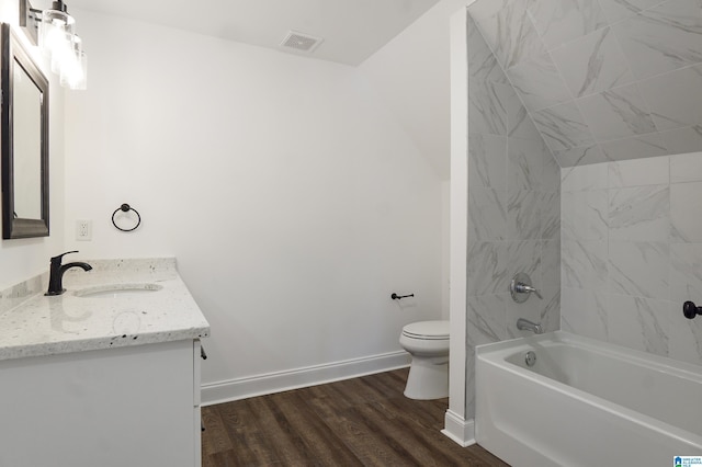 full bathroom with vanity, toilet, wood-type flooring, and tiled shower / bath