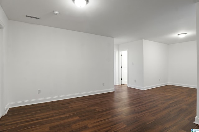 spare room featuring dark wood-type flooring