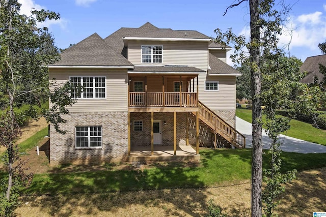 rear view of property featuring a patio area, a yard, and a deck