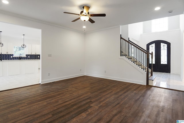 unfurnished living room featuring hardwood / wood-style flooring, french doors, ceiling fan, and ornamental molding