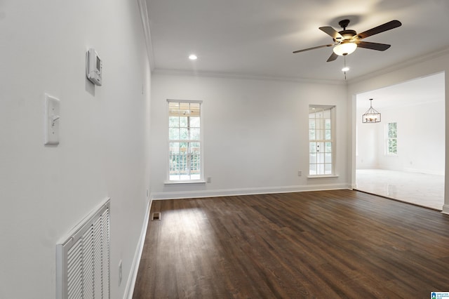 empty room featuring ceiling fan with notable chandelier, dark hardwood / wood-style floors, and crown molding