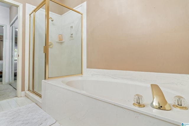 bathroom featuring tile patterned flooring and shower with separate bathtub