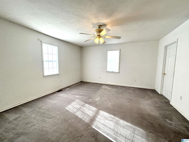 carpeted spare room featuring a textured ceiling and ceiling fan