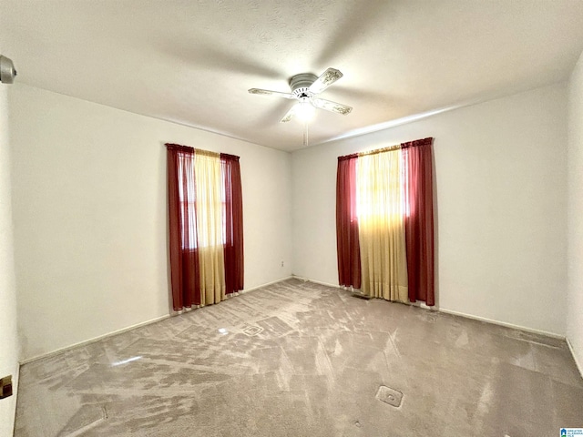 carpeted spare room featuring ceiling fan and a textured ceiling