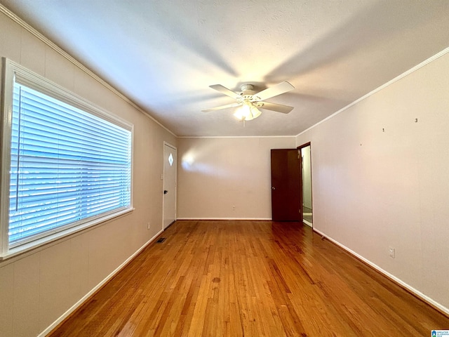 unfurnished room with hardwood / wood-style floors, ceiling fan, and crown molding