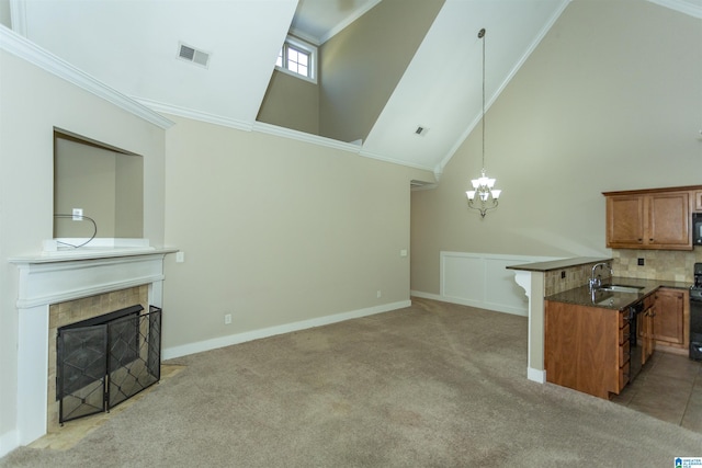 living room with a tile fireplace, light carpet, a high ceiling, ornamental molding, and sink