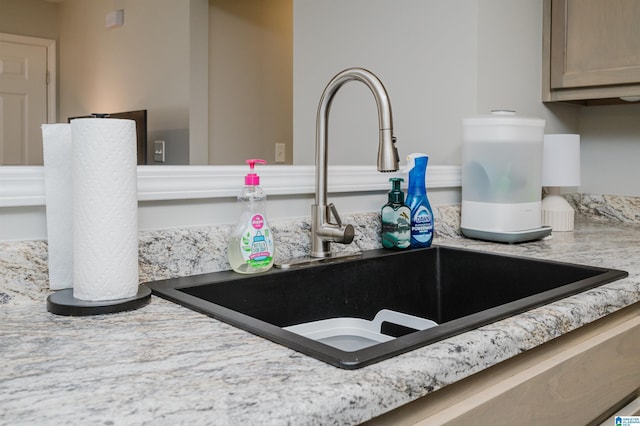 interior details featuring light stone counters and sink