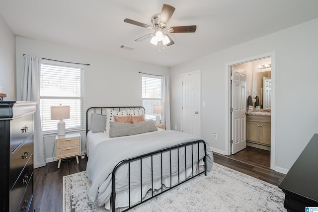 bedroom with ensuite bathroom, ceiling fan, and dark wood-type flooring