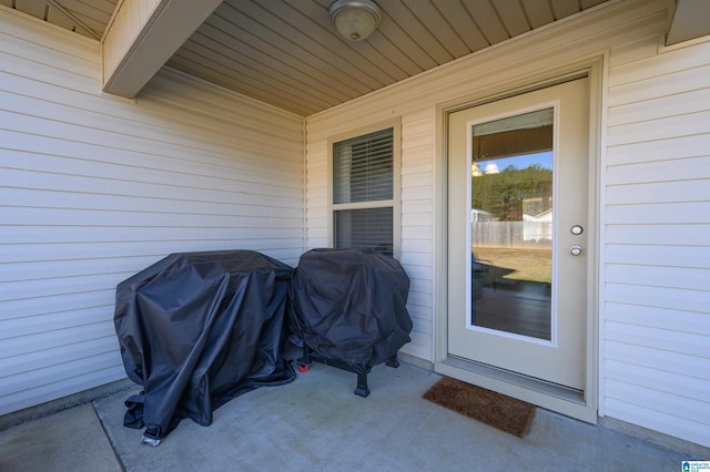 view of exterior entry with a patio area