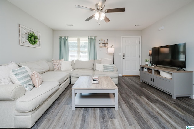 living room featuring ceiling fan and dark hardwood / wood-style floors